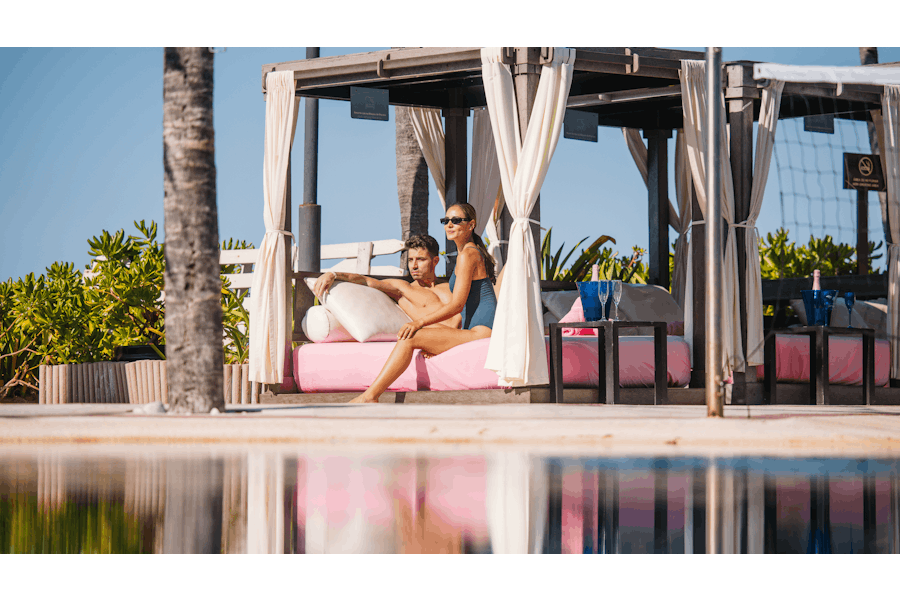 Pareja en una elegante cabaña frente a la piscina.